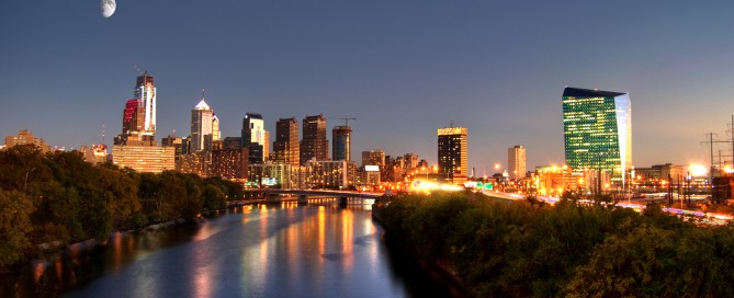 Downtown image of Philly taken at night with a clear sky and the moon.