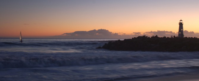Lighthouse at Santa Cruz, California at sunset with a windsurfer.
