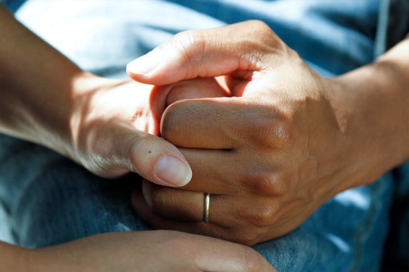 couple holding hands discussing the cremation process