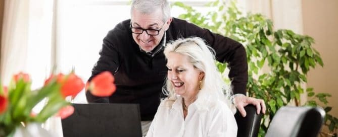 Happy, mature couple looking at laptop