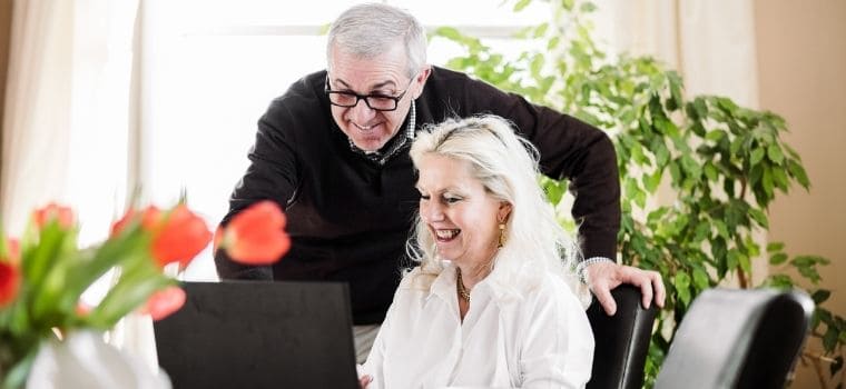 Happy, mature couple looking at laptop