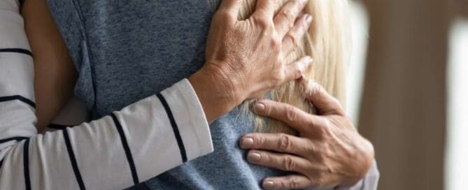 older woman hugging younger woman