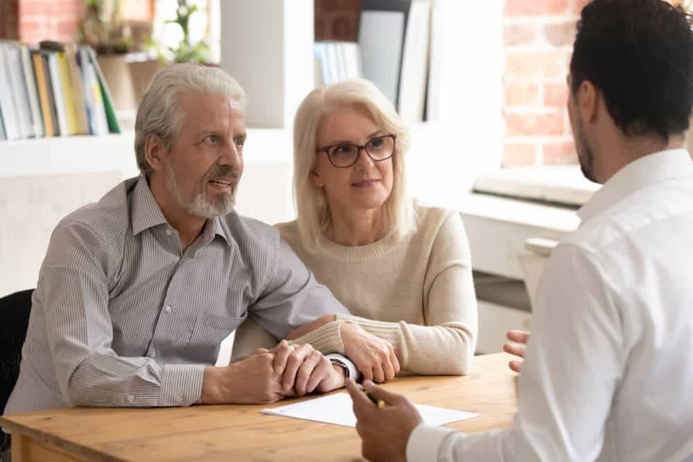 Funeral director discusses different funeral home cremation packages with an older couple.